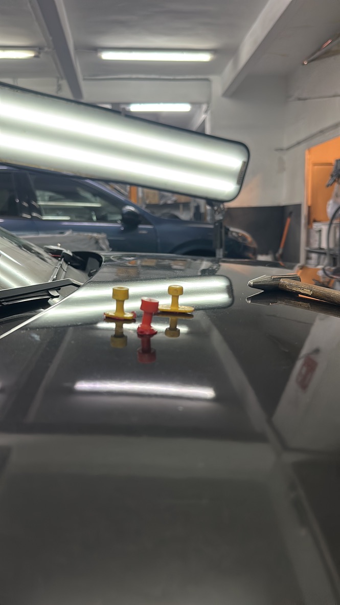 Herramientas y lámpara durante una reparación de capó sin pintar